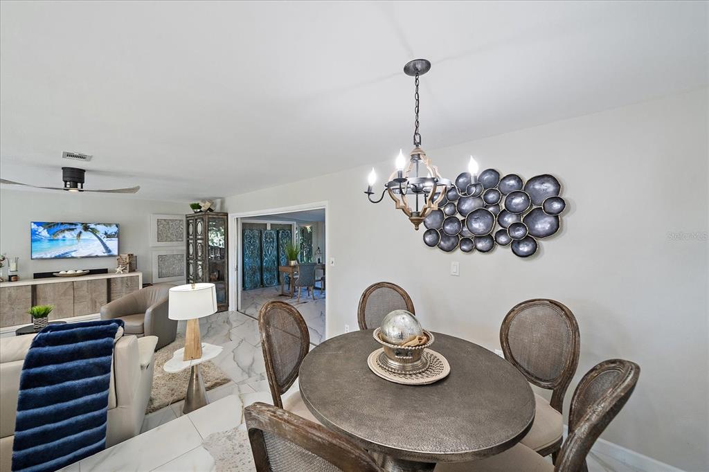 3149 Homasassa Road Sarasota, FL 34239 - Photo 18 of 62 a dining room with furniture a kitchen and chandelier