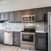 a kitchen with stainless steel appliances granite countertop a refrigerator stove a sink and a microwave