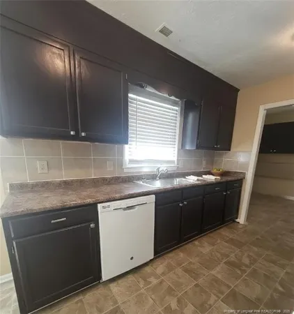 a kitchen with a sink stove top oven and cabinets