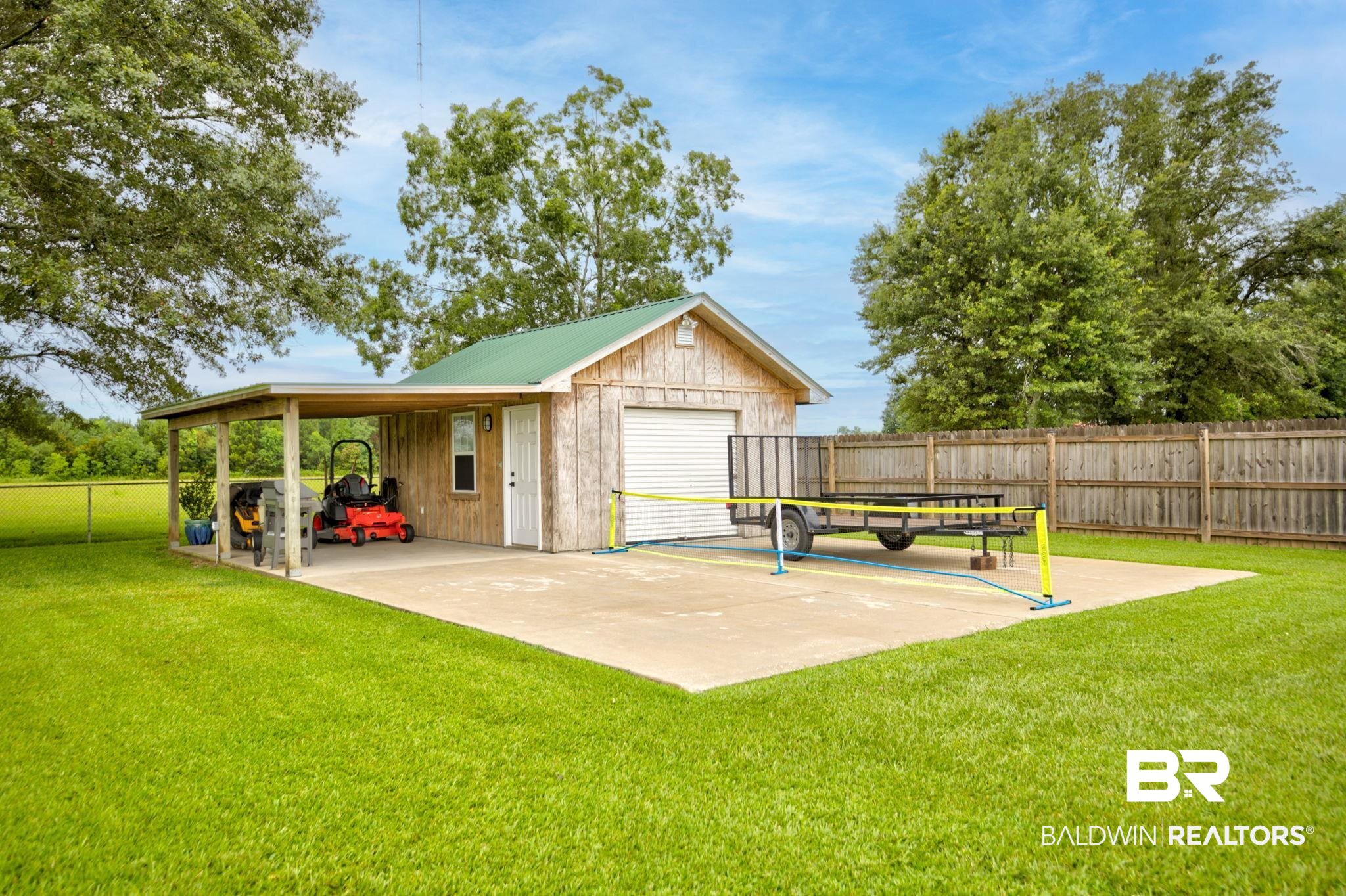 18732 Fairground Road Robertsdale, AL 36567 - Photo 41 of 46 Exterior space with an outdoor structure, a patio area, and a trampoline