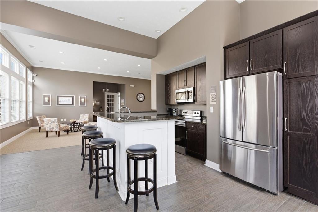 411 Stockton Ridge Cranberry Township, PA 16066 - Photo 29 of 32 a kitchen with stainless steel appliances a refrigerator a stove a dining table and chairs with wooden floor