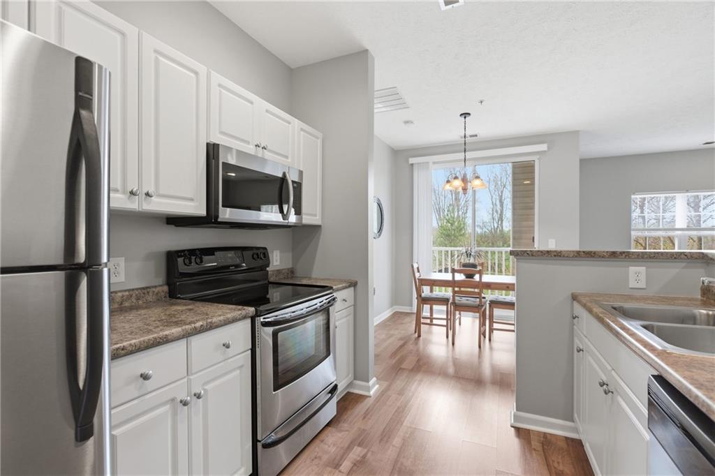 411 Stockton Ridge Cranberry Township, PA 16066 - Photo 10 of 32 a kitchen with granite countertop appliances cabinets and a wooden floor