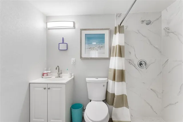 a bathroom with a toilet sink vanity and mirror