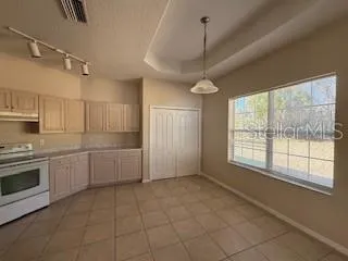a kitchen with granite countertop a stove a sink and a refrigerator