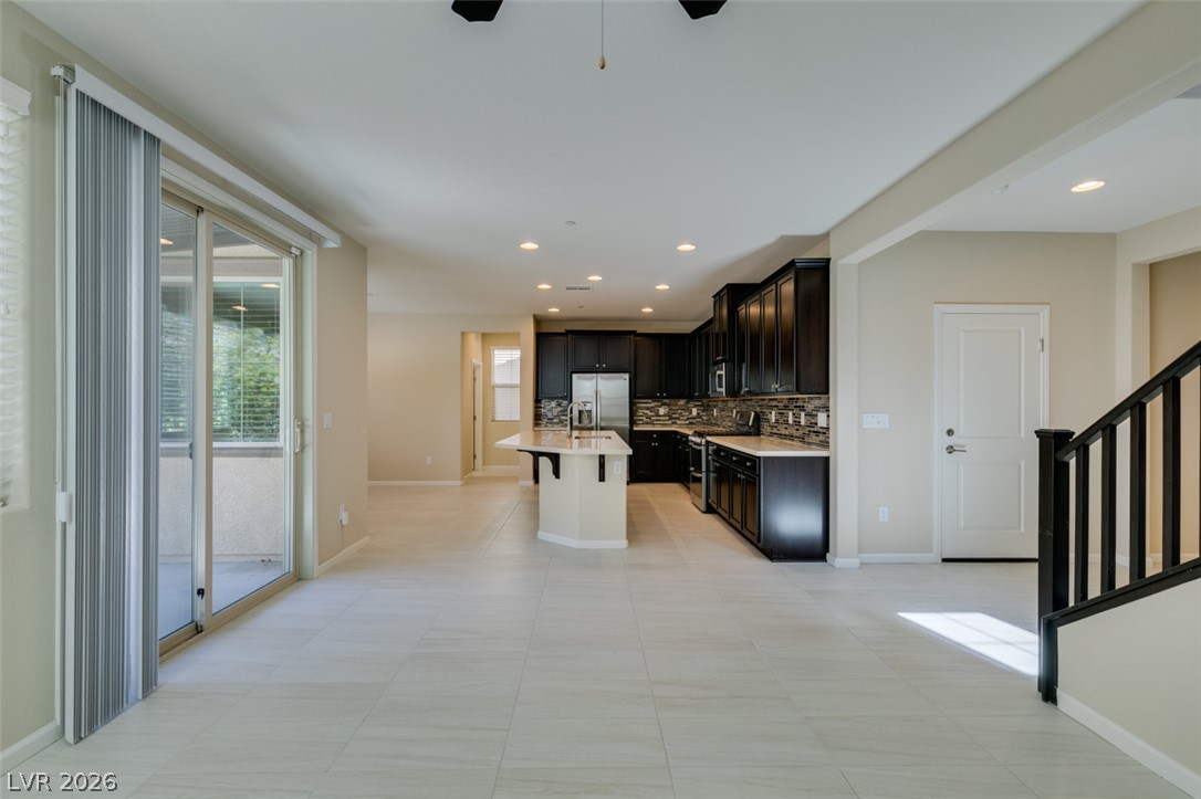 2549 Sable Ridge Street Henderson, NV 89044 - Photo 48 of 48 A well-lit open floorplan seamlessly integrates kitchen and living spaces, offering bright tile floors and direct patio access.