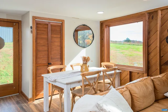 a dining room with furniture and a large window