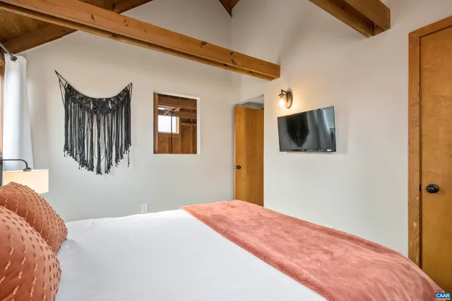 a bedroom with a bed and a flat screen tv