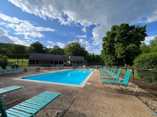 a view of a swimming pool with lounge chairs in patio