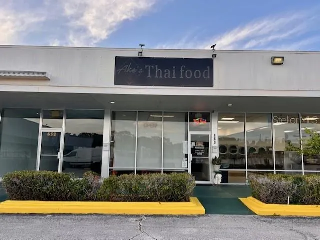 a view of a swimming pool with a table and chairs under an umbrella
