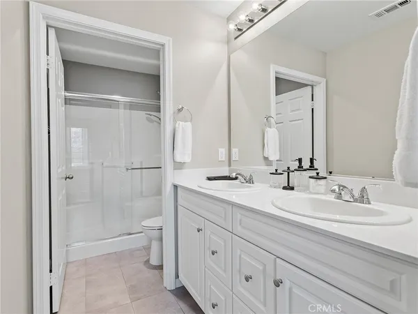 a bathroom with a double vanity sink mirror double and shower