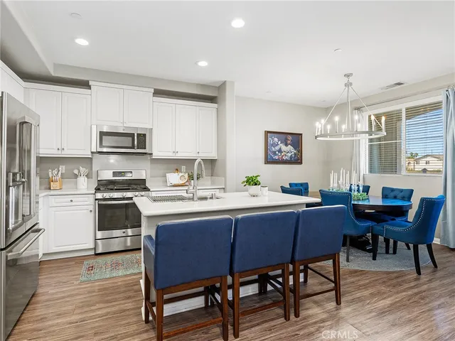 a kitchen with a dining table chairs and refrigerator
