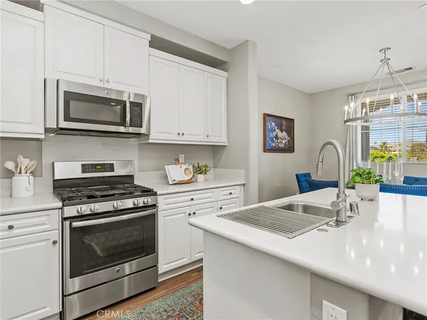 a kitchen with granite countertop a stove top oven microwave and cabinets