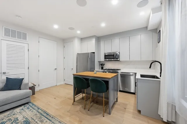 a view of kitchen with stainless steel appliances granite countertop sink stove and white cabinets