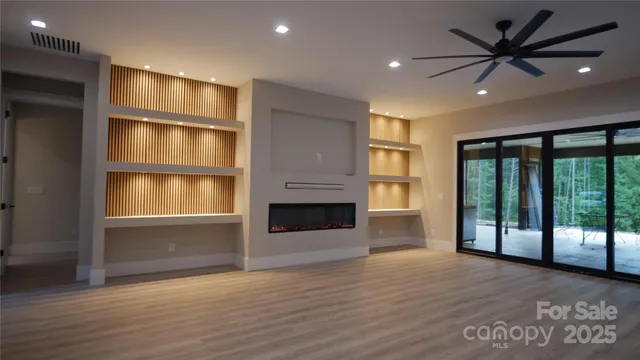 a view of an empty room with a fireplace and a window