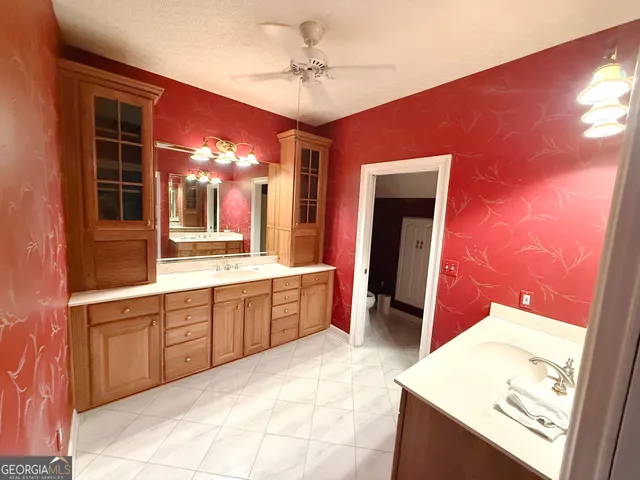 a large bathroom with a sink a vanity and a mirror
