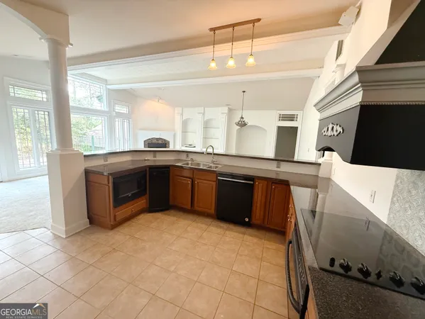 a large kitchen with stainless steel appliances granite countertop a sink and cabinets