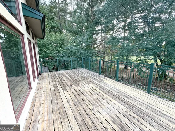 a view of balcony with wooden floor and fence