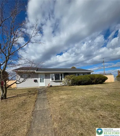 a view of house with yard and sitting area
