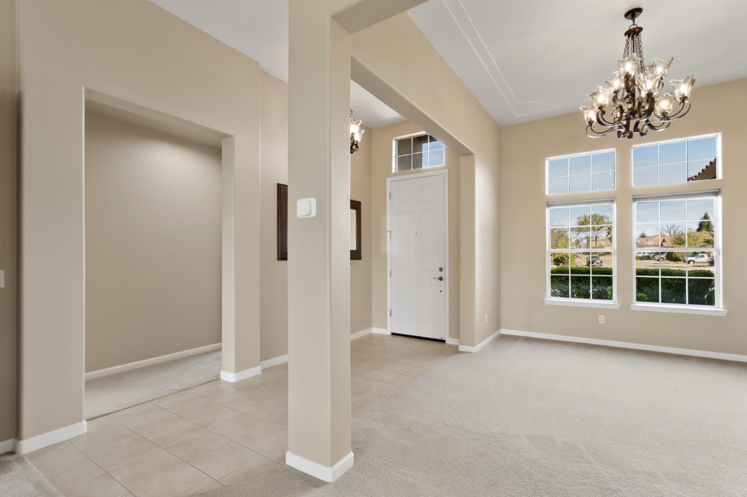 702 Shakeley Lane Ione, CA 95640 - Photo 13 of 71 an empty room with chandelier and windows