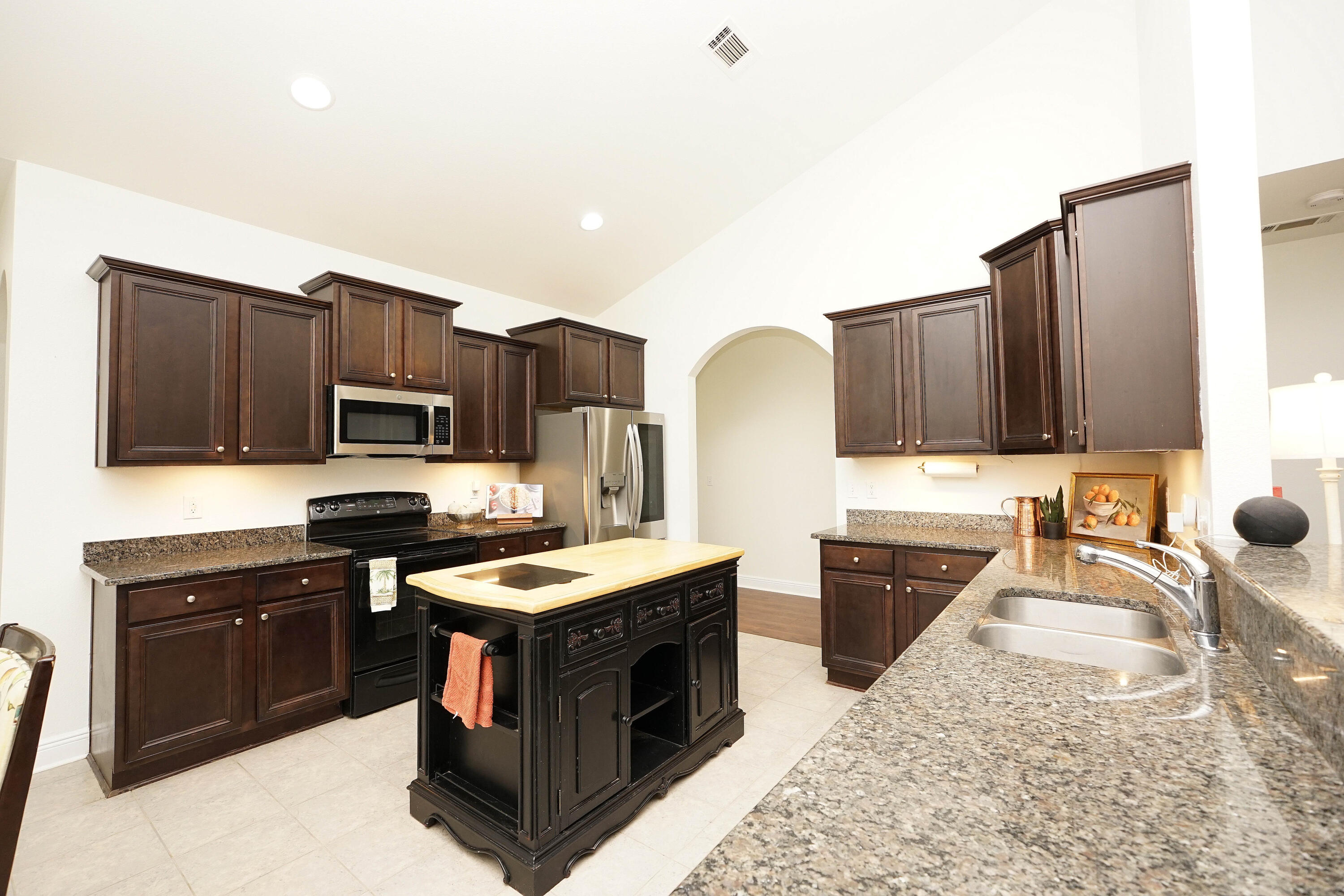614 Red Fern Road Crestview, FL 32536 - Photo 14 of 43 a kitchen with stainless steel appliances granite countertop a stove top oven a sink dishwasher and a microwave with wooden cabinets