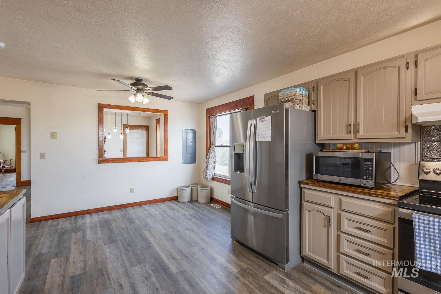 6050 Elmore Road Fruitland, ID 83619 - Photo 12 of 48 Kitchen featuring butcher block counters, appliances with stainless steel finishes, a textured ceiling, dark wood finished floors, and ceiling fan