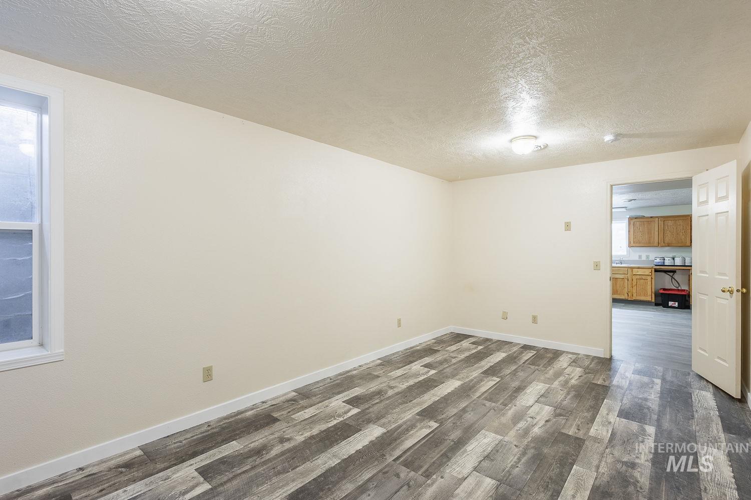 6050 Elmore Road Fruitland, ID 83619 - Photo 31 of 48 Unfurnished room with a textured ceiling and dark wood-type flooring