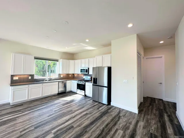 a kitchen with a refrigerator and a stove top oven