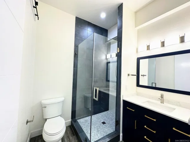 a bathroom with a toilet sink shower and mirror