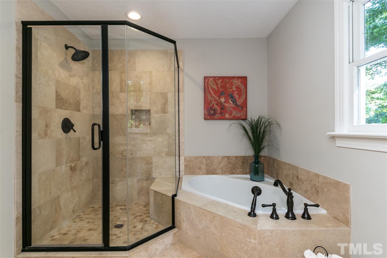 4908 Fielding Drive Raleigh, NC 27606 - Photo 16 of 25 The master bathroom has been so beautifully renovated! The corner garden tub is perfect for a relaxing soak and the shower is so beautiful finished off with oil-rubbed bronze frame and fixtures.