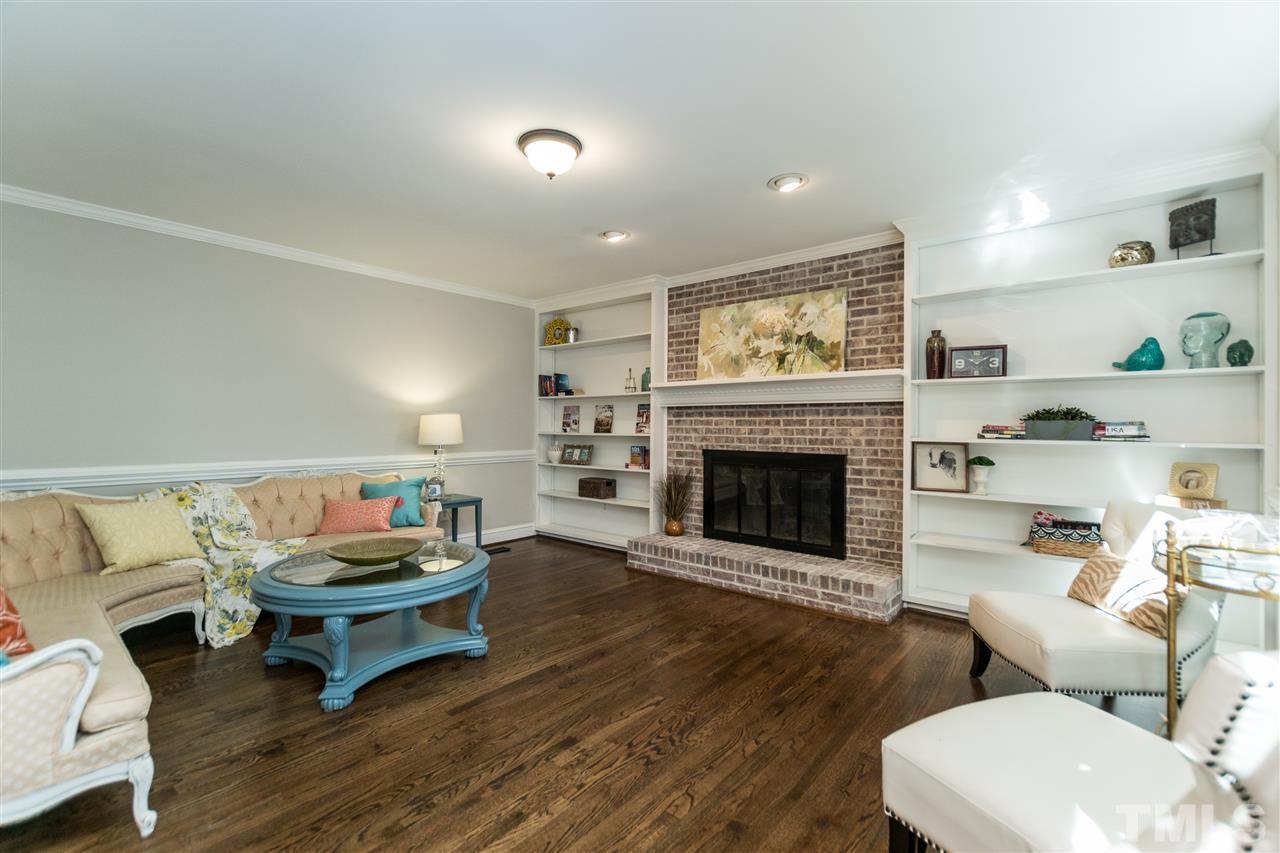 4908 Fielding Drive Raleigh, NC 27606 - Photo 4 of 25 The wood burning fireplace in the living room is a showstopper! It has a beautiful soft white wash finish. The custom shelving that surrounds it is a book-lover's dream. The size of the room is quite large and it opens into the breakfast room and kitchen.