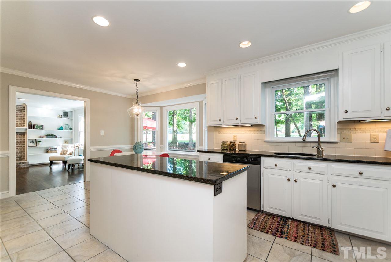 4908 Fielding Drive Raleigh, NC 27606 - Photo 7 of 25 The kitchen is a wonderful size and has plenty of counter space with a large island in the center. The white cabinets, chic black granite counters, and white and gray tile flooring is a modern, yet timeless combination!