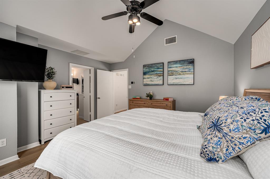 6053 Buffridge Trail Dallas, TX 75252 - Photo 22 of 40 a bedroom with a bed a dresser and a flat screen tv