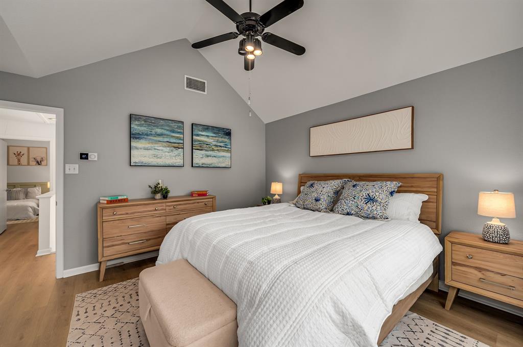 6053 Buffridge Trail Dallas, TX 75252 - Photo 23 of 40 a bedroom with a bed and a chandelier