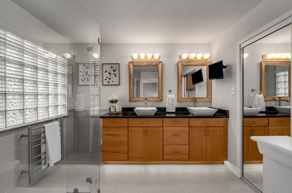 6053 Buffridge Trail Dallas, TX 75252 - Photo 25 of 40 a bathroom with a double vanity sink a mirror and a bathtub