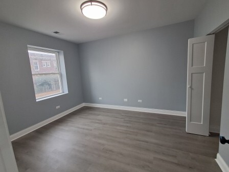 935 West Marquette Road, Unit 9433 Chicago, IL 60621 - Photo 6 of 25 an empty room with wooden floor and windows