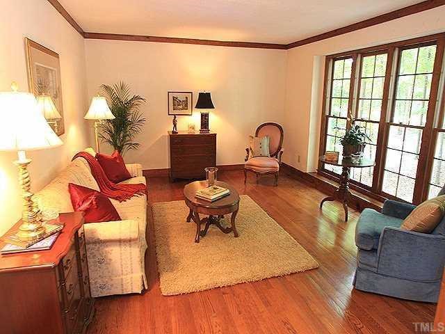 10220 Bushveld Lane Raleigh, NC 27613 - Photo 3 of 12 a living room with furniture a rug and a floor to ceiling window