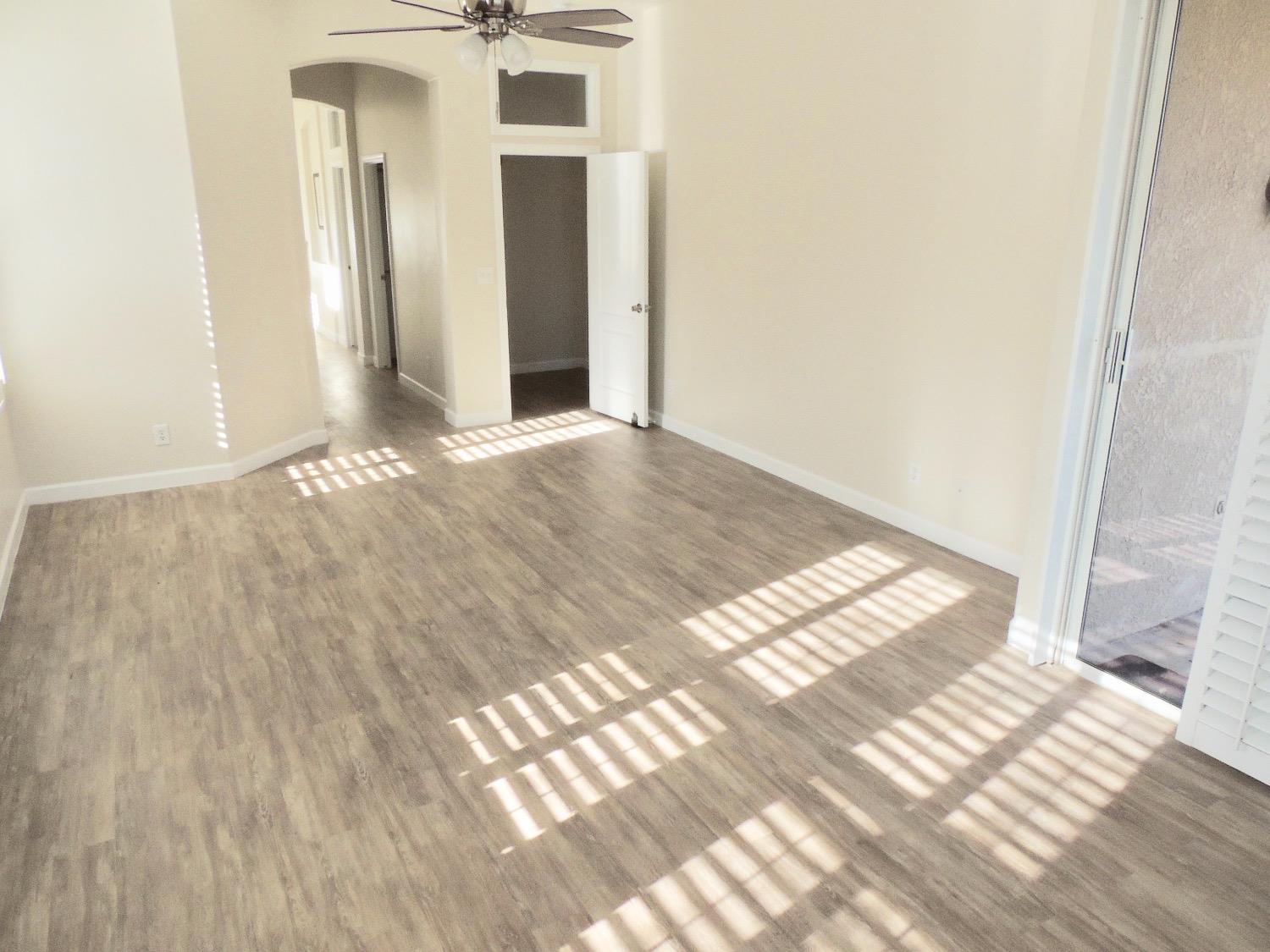 3051 Carson Avenue Clovis, CA 93611 - Photo 18 of 40 a view of an empty room with wooden floor and a bathroom