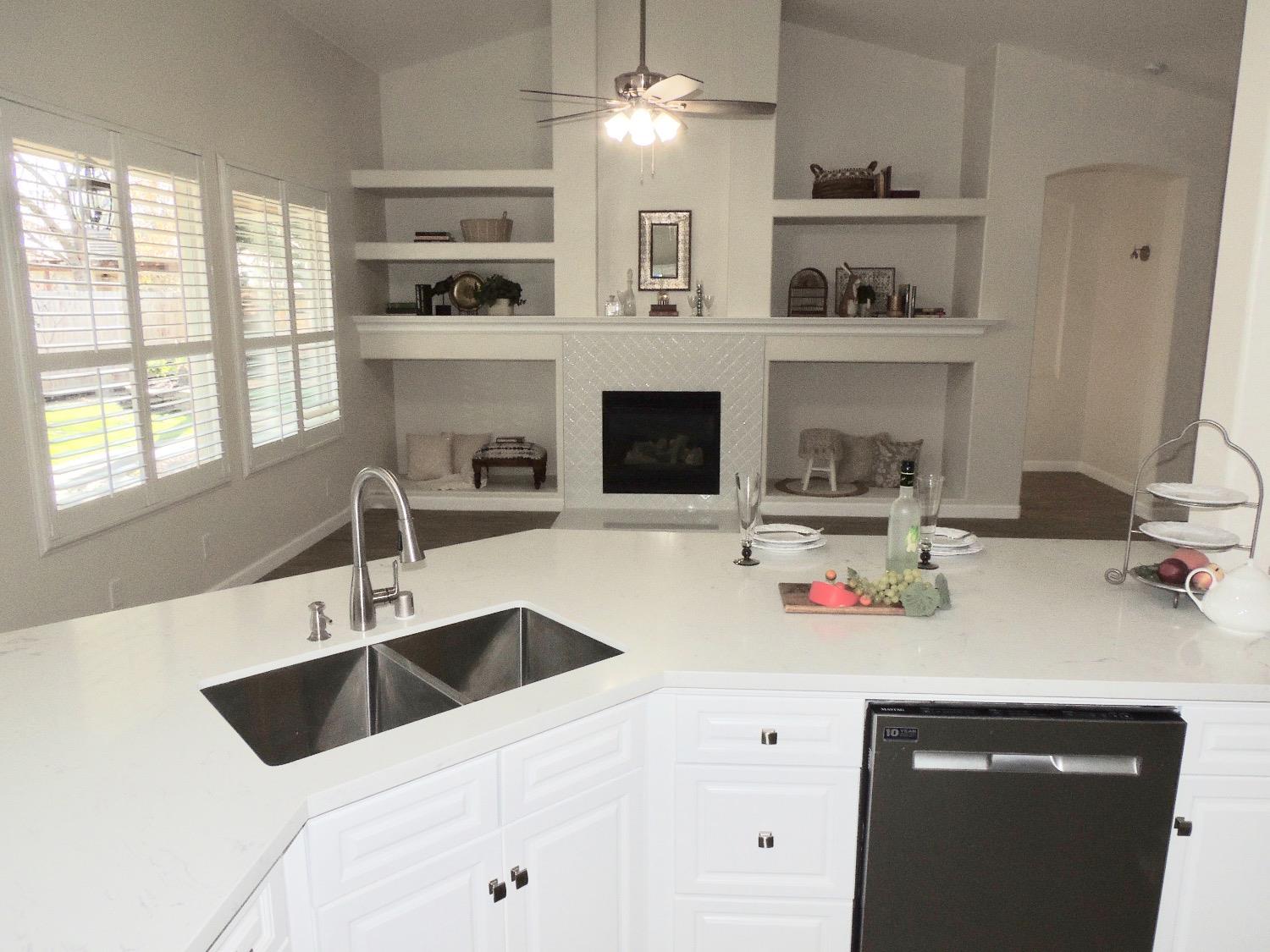 3051 Carson Avenue Clovis, CA 93611 - Photo 10 of 40 a kitchen with a sink dishwasher a washer and dryer with wooden floor