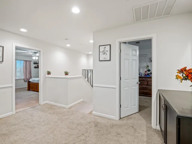 a view of a hallway with kitchen and refrigerator