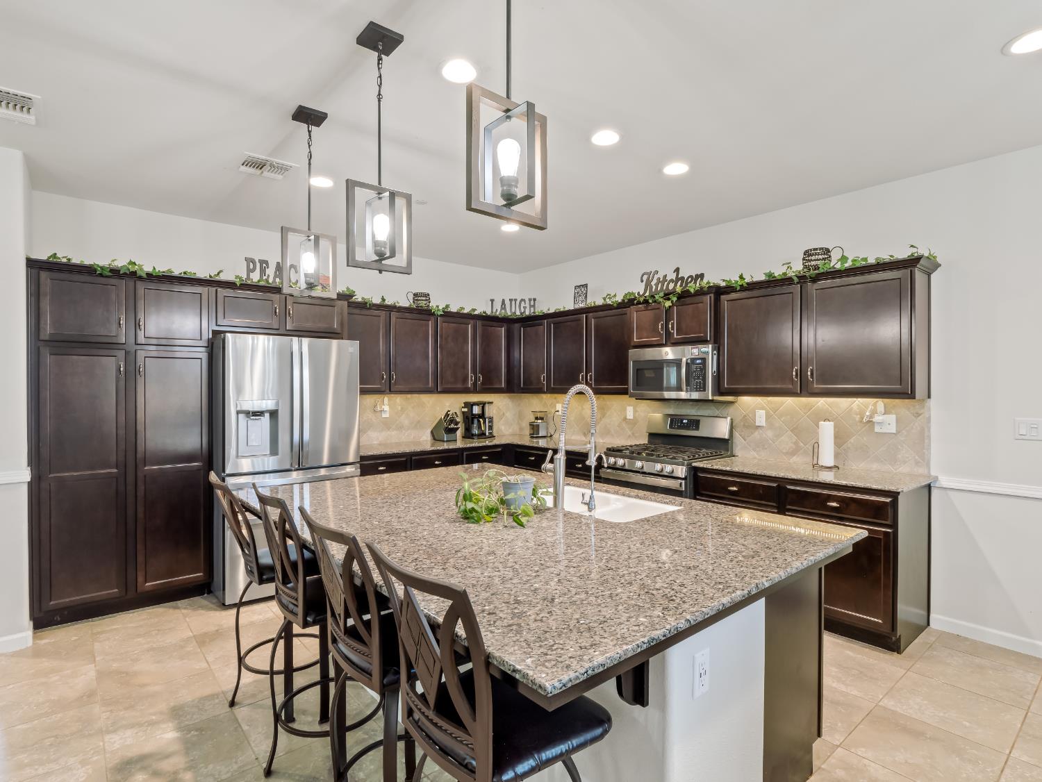 3925 Griffith Avenue Clovis, CA 93619 - Photo 28 of 40 a kitchen with stainless steel appliances granite countertop a kitchen island a stove and a refrigerator