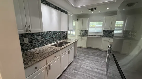 a kitchen with stainless steel appliances granite countertop a stove top oven a sink and a granite counter tops