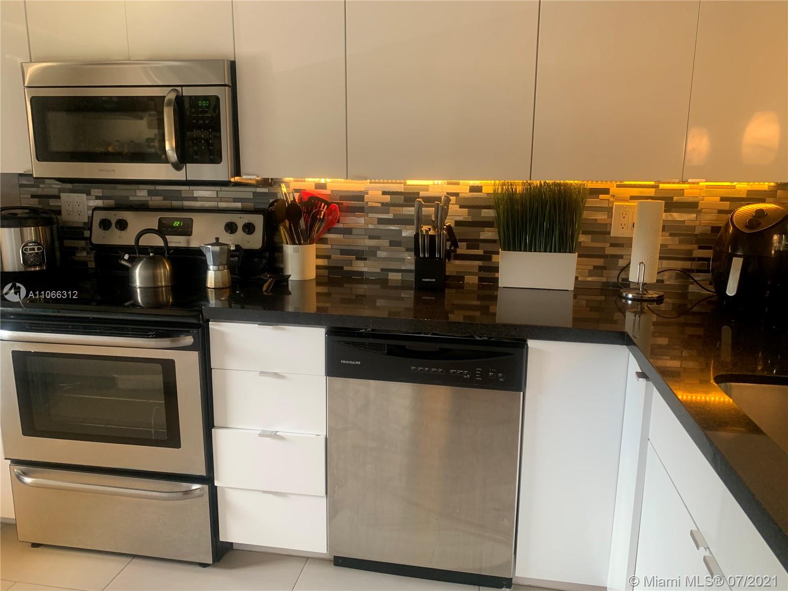 4018 Del Rio Way, Unit 4018 Sunrise, FL 33351 - Photo 20 of 94 a kitchen with stainless steel appliances a stove a microwave and a counter