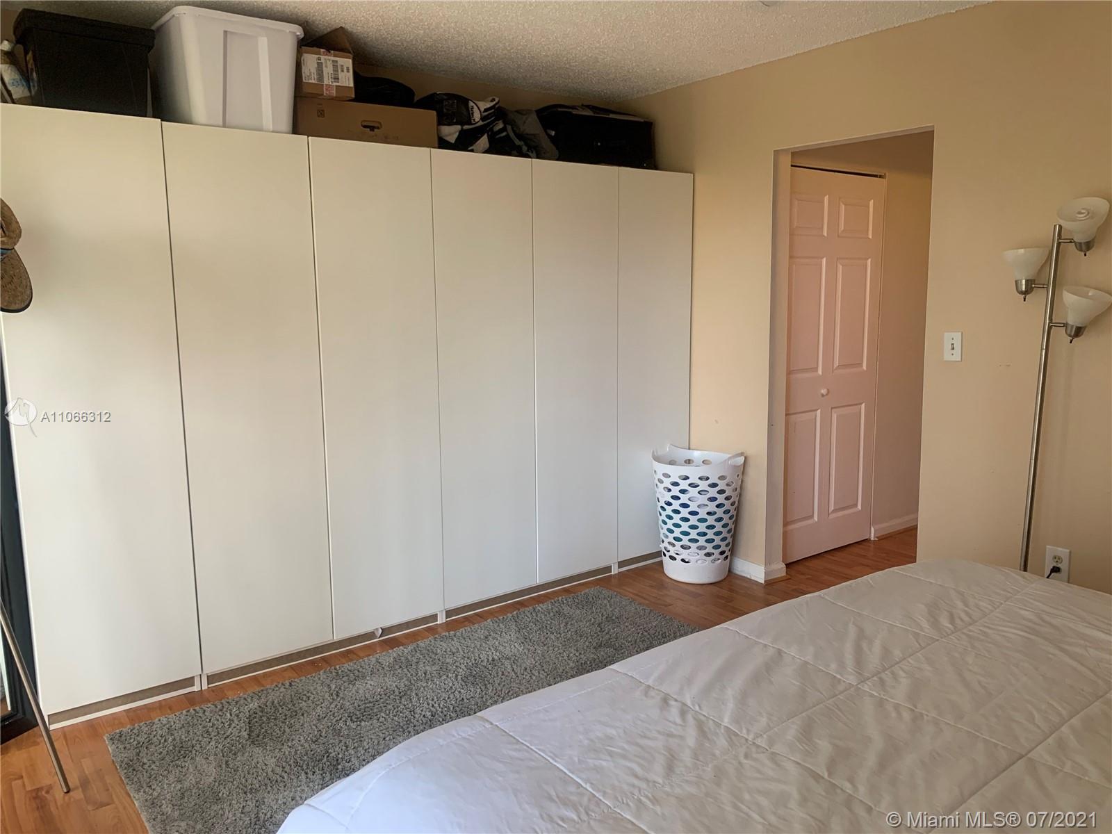 4018 Del Rio Way, Unit 4018 Sunrise, FL 33351 - Photo 57 of 94 a bedroom with a white bed and cabinet