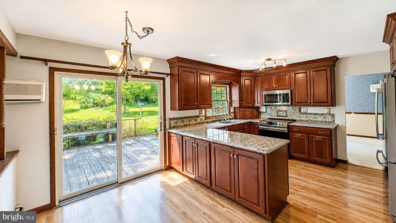 223 Trythall Road Elverson, PA 19520 - Photo 21 of 78 a kitchen with stainless steel appliances granite countertop a stove a sink and a wooden floors