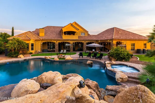 a kitchen with stainless steel appliances granite countertop a stove a sink dishwasher a dining table and chairs with wooden floor