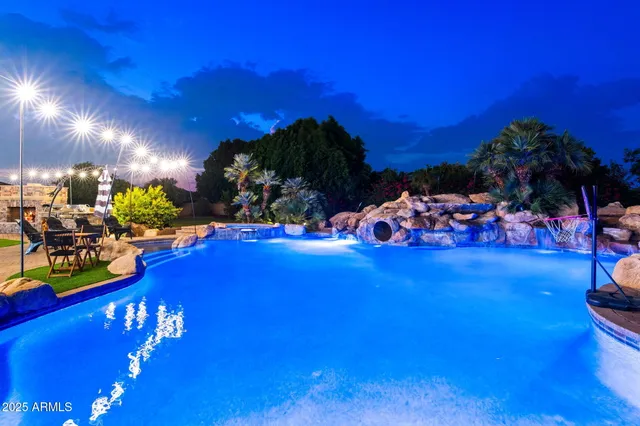 a kitchen with stainless steel appliances granite countertop a refrigerator a sink dishwasher a dining table and chairs with wooden floor