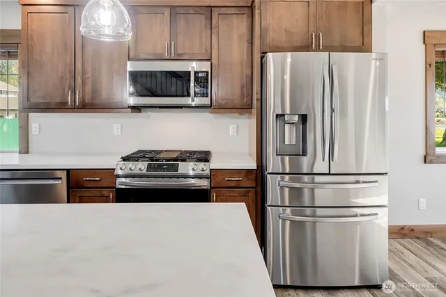 a kitchen with stainless steel appliances a refrigerator stove and microwave