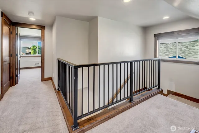 a view of a hallway with wooden floor and windows