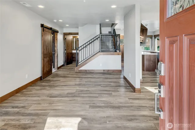 a view of a hallway with wooden floor and staircase
