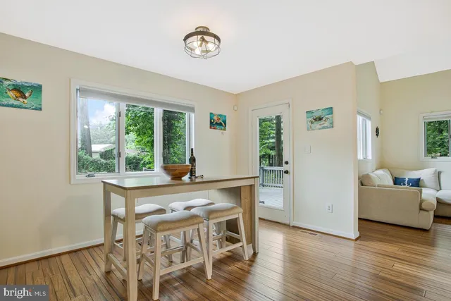 a kitchen with stainless steel appliances granite countertop a refrigerator a stove top oven a sink dishwasher and white cabinets with wooden floor